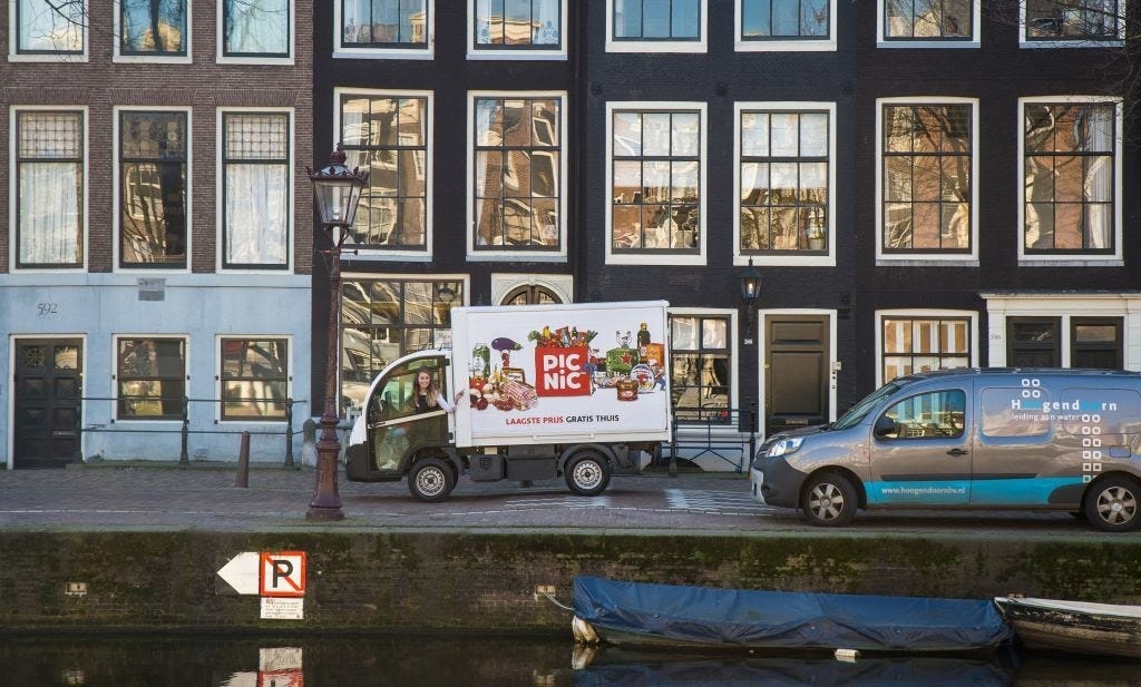 A Picnic Electric Vehicle being parked on a narrow Amsterdam Street